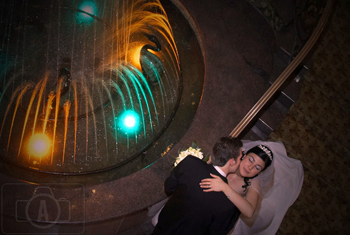 bride and groom kiss in the  fountain